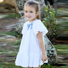 white dress with large blue bow by martin aranda